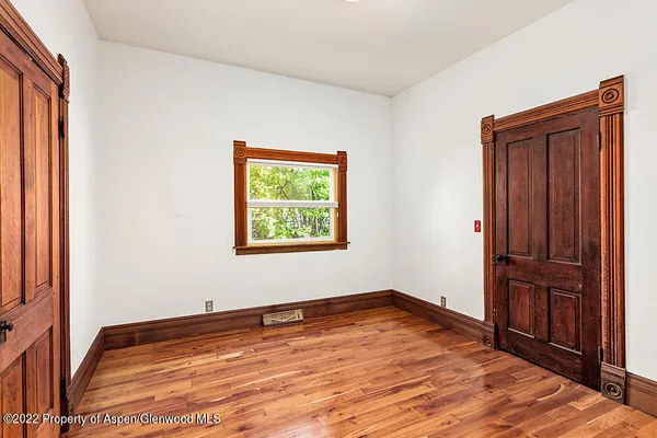 an empty room with wooden floor and closet