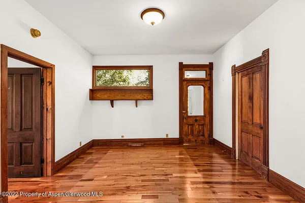 a view of empty room with wooden floor and window