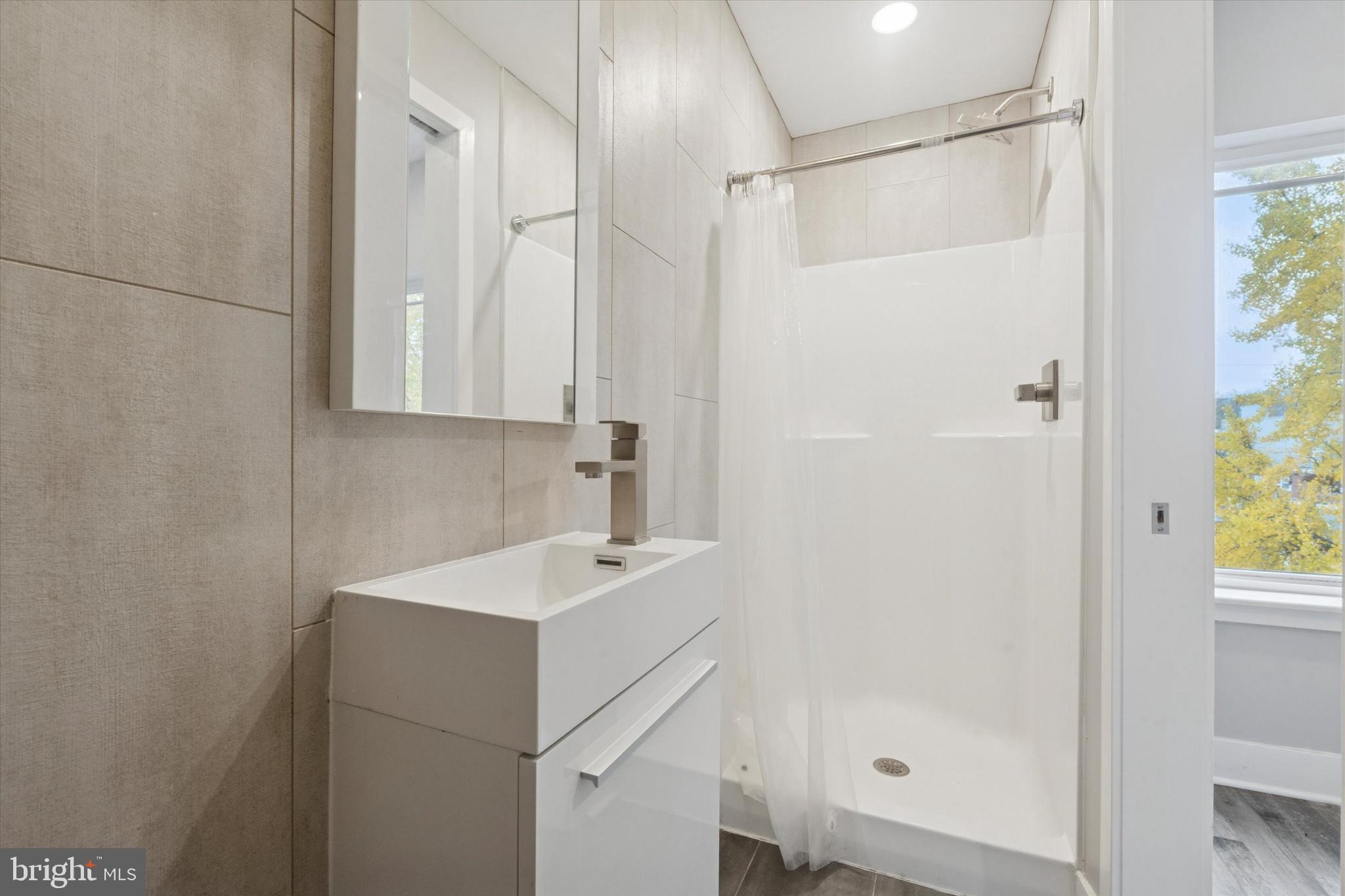 3817 Wallace Street Philadelphia, PA 19104 - Photo 18 of 25 a bathroom with a sink a mirror and a shower