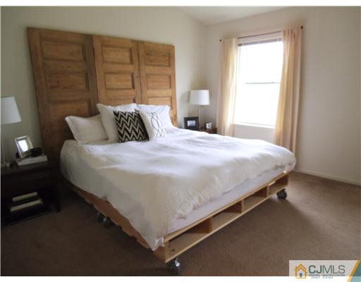 5 Stony Hill Road Jamesburg, NJ 08831 - Photo 11 of 17 a large bed sitting in a bedroom next to a window