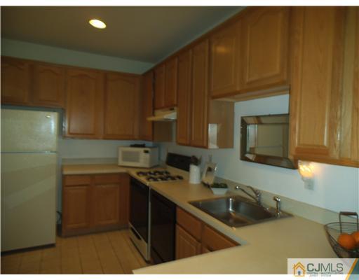 5 Stony Hill Road Jamesburg, NJ 08831 - Photo 3 of 17 a kitchen with stainless steel appliances a sink a stove a microwave a sink and cabinets