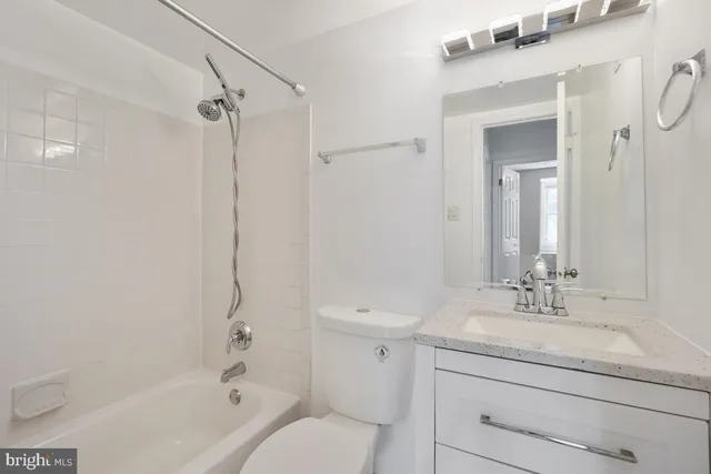 a bathroom with a granite countertop sink a toilet and shower