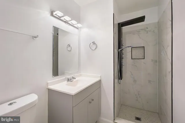 a bathroom with a sink a toilet and shower