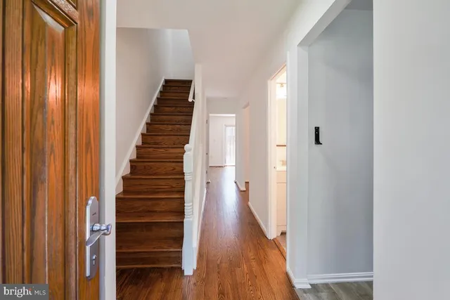 a view of a hallway with wooden floor and entryway