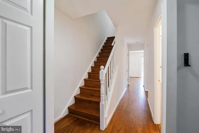 a view of a hallway with wooden floor and entryway