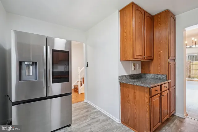 a kitchen with stainless steel appliances granite countertop a refrigerator a stove and a wooden cabinets