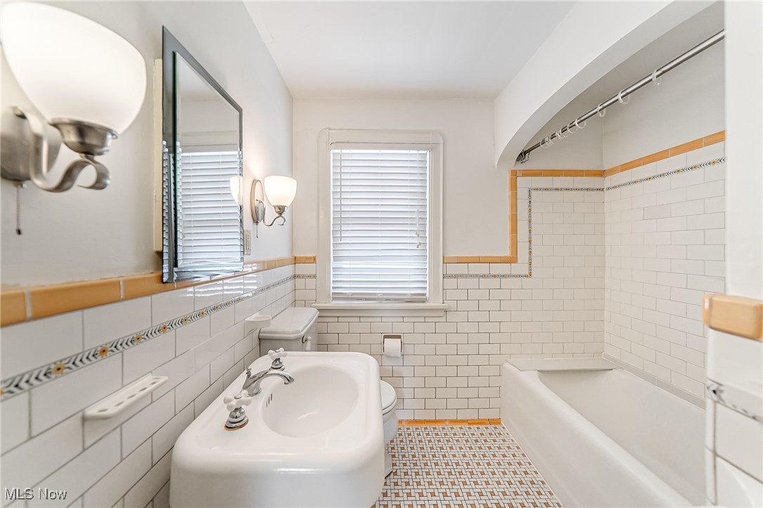 6711 Forest Avenue Parma, OH 44129 - Photo 25 of 33 Bathroom with tile walls, a wainscoted wall, tub / shower combination, and tile patterned floors