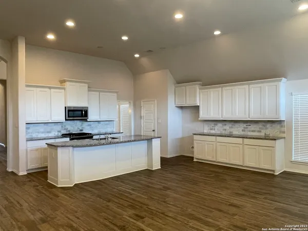 a kitchen with stainless steel appliances a stove top oven a sink and a refrigerator