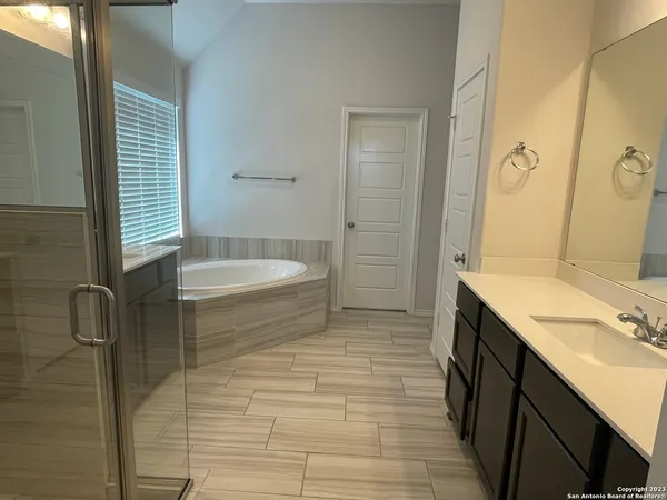 a bathroom with a sink a toilet a mirror and shower