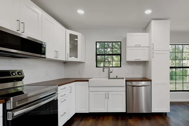 a kitchen with white cabinets stainless steel appliances and sink