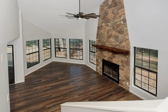 wooden floor fireplace and windows in an empty room