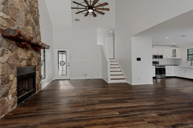 a view of a livingroom with wooden floor and a fireplace