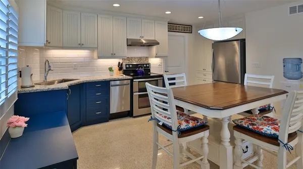 a kitchen with stainless steel appliances granite countertop a stove a sink and a refrigerator