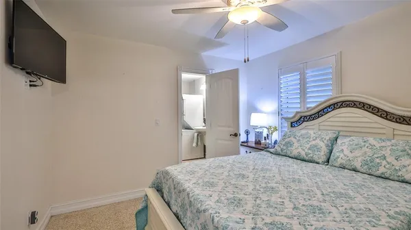 a bedroom with a bed and a flat tv screen on dresser