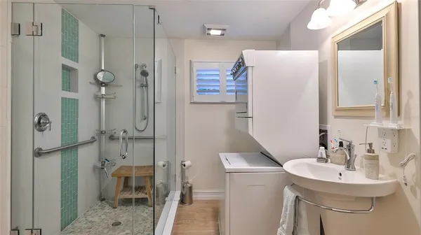 a bathroom with a sink shower and a mirror