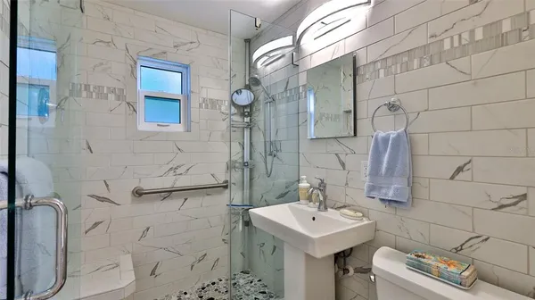 a bathroom with a sink a toilet and shower