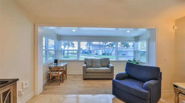 a living room with furniture and a view of kitchen