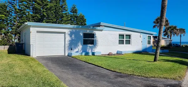 a backyard of a house with potted plants and large tree