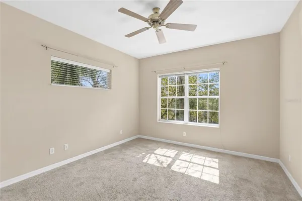 an empty room with a window and a ceiling fan