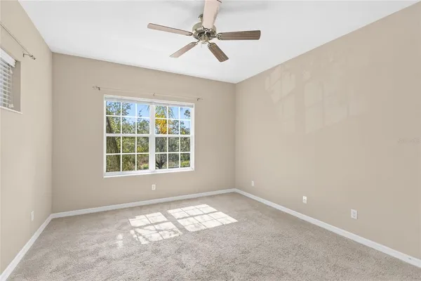 an empty room with a window and a fan