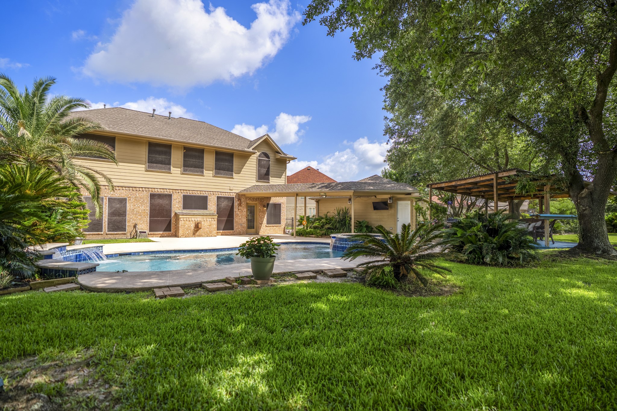 5807 Sequoia Trace Court Spring, TX 77379 - Photo 33 of 50 This wider backyard view shows how the pool, spa, covered patio, gazebo, and shaded lawn all work together, creating the kind of outdoor living space that makes Windrose golf course life feel easy to enjoy.