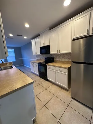 a kitchen with stainless steel appliances granite countertop a refrigerator sink and stove