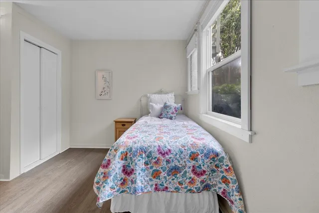 a bedroom with a bed and wooden floor