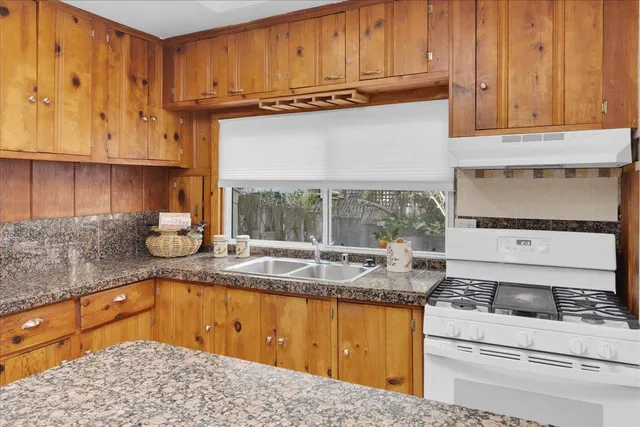 a kitchen with stainless steel appliances granite countertop a sink stove and cabinets