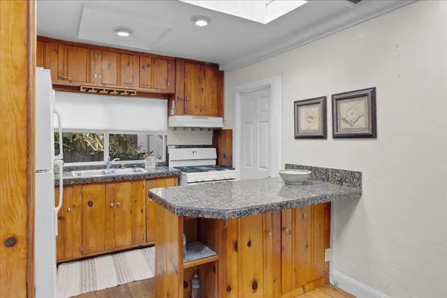 a kitchen with stainless steel appliances granite countertop a sink a refrigerator and a stove