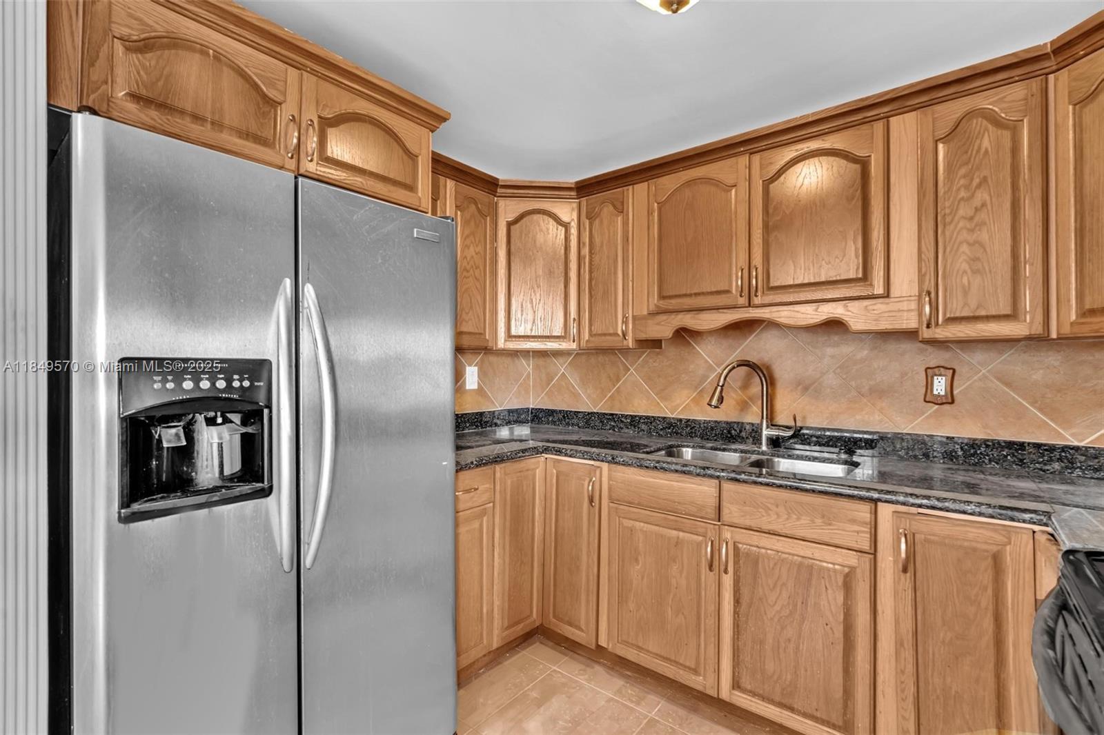 3660 Southwest 60th Avenue, Unit 2 Davie, FL 33314 - Photo 11 of 34 a kitchen with granite countertop a sink a refrigerator and cabinets