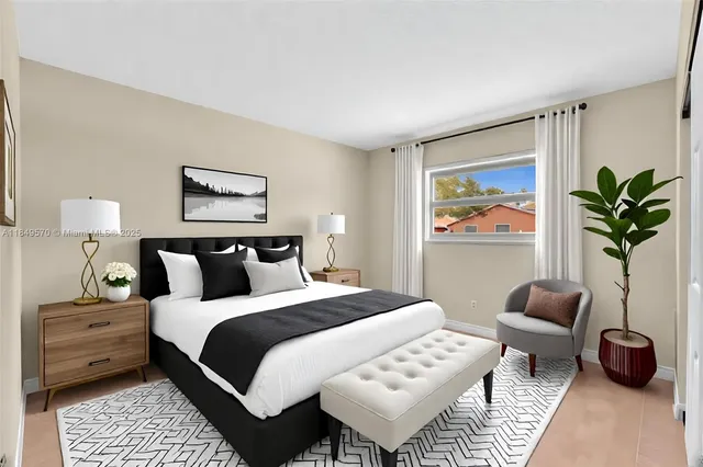 a bedroom with a bed a couch and a painting on the wall