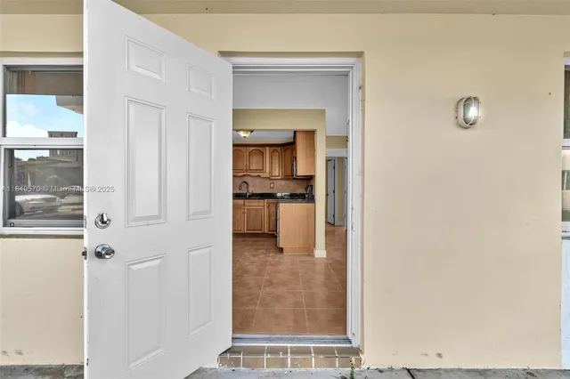 a view of a hallway with wooden floor and a living room