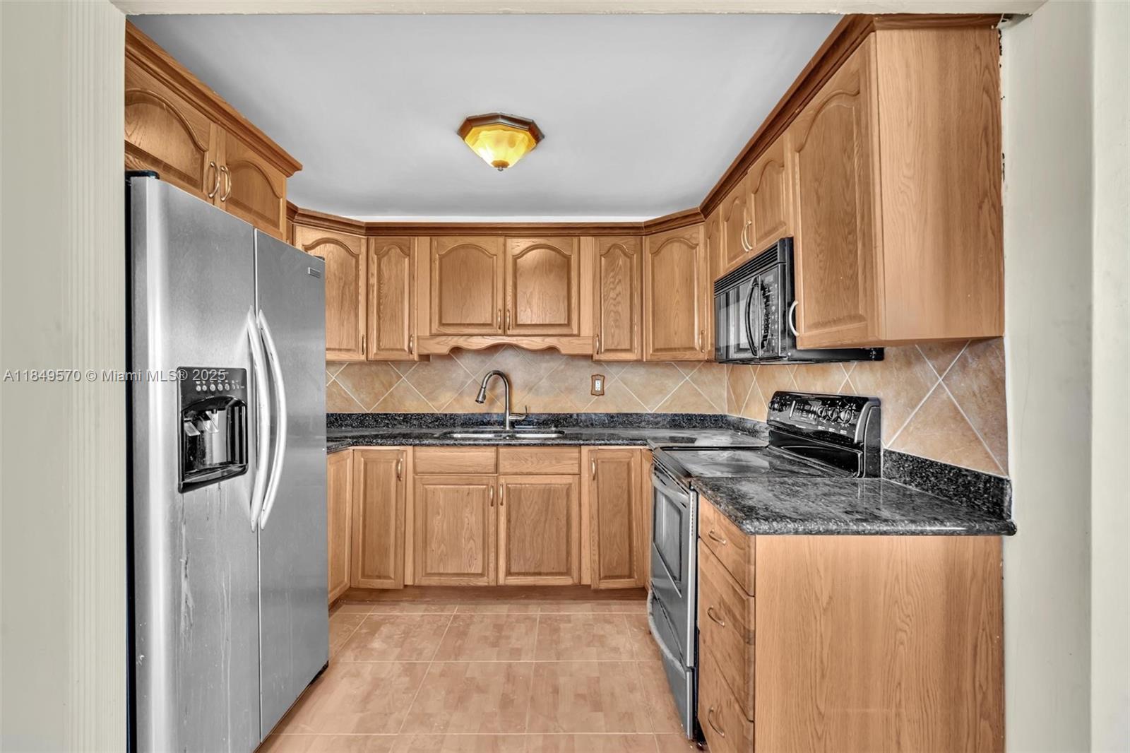 3660 Southwest 60th Avenue, Unit 2 Davie, FL 33314 - Photo 9 of 34 a kitchen with stainless steel appliances granite countertop a sink a stove a refrigerator a microwave and cabinets