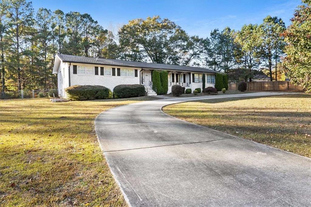 a front view of a house with a yard and trees