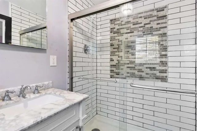 a bathroom with a sink a vanity and a shower