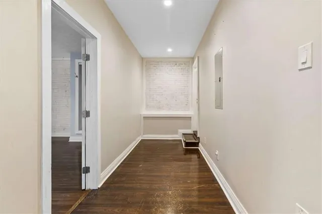 a view of a hallway with wooden floor and staircase