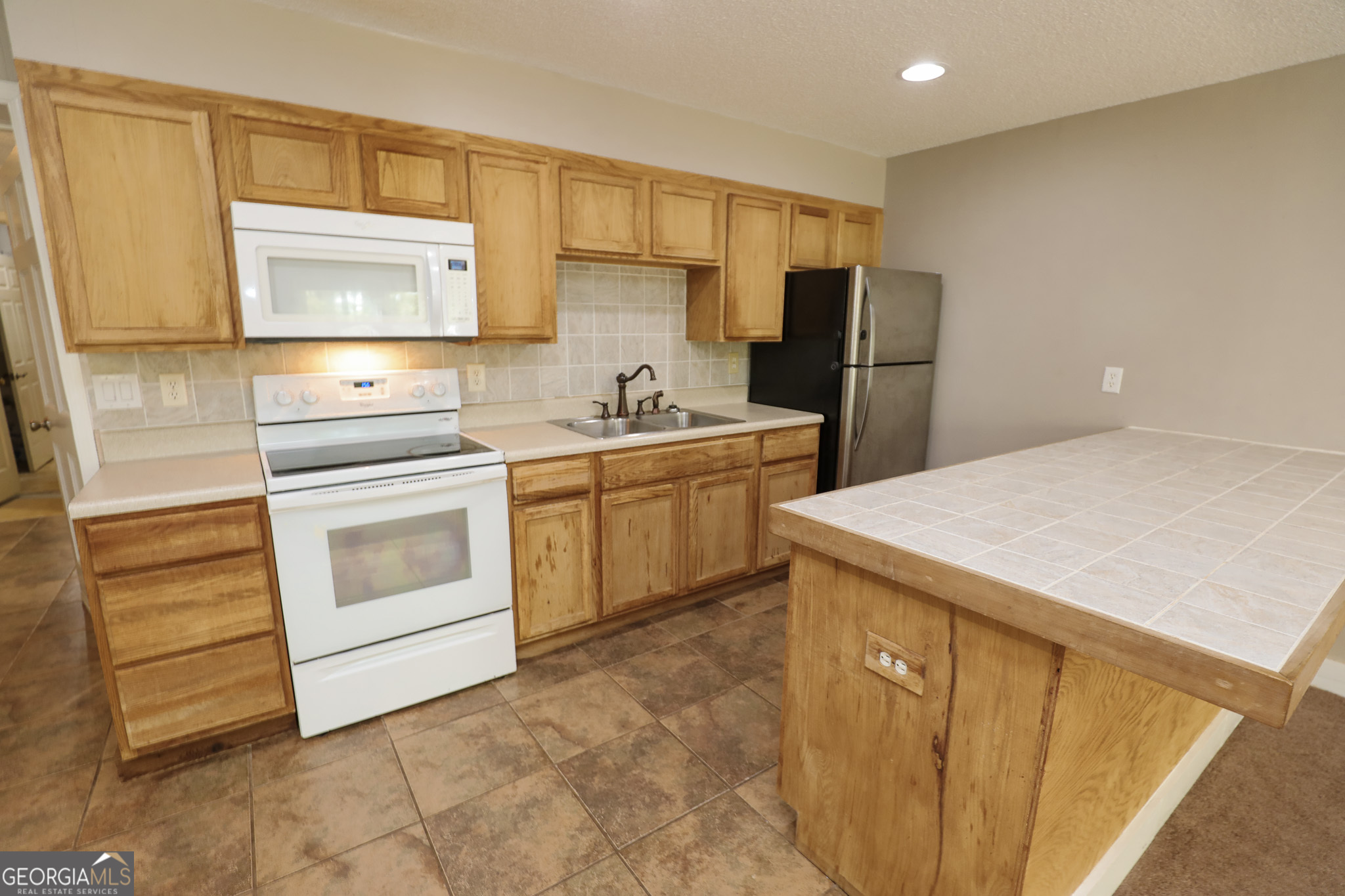 1017 Dr Bruce Jackson Road Newnan, GA 30263 - Photo 26 of 52 a kitchen with a sink a stove and refrigerator