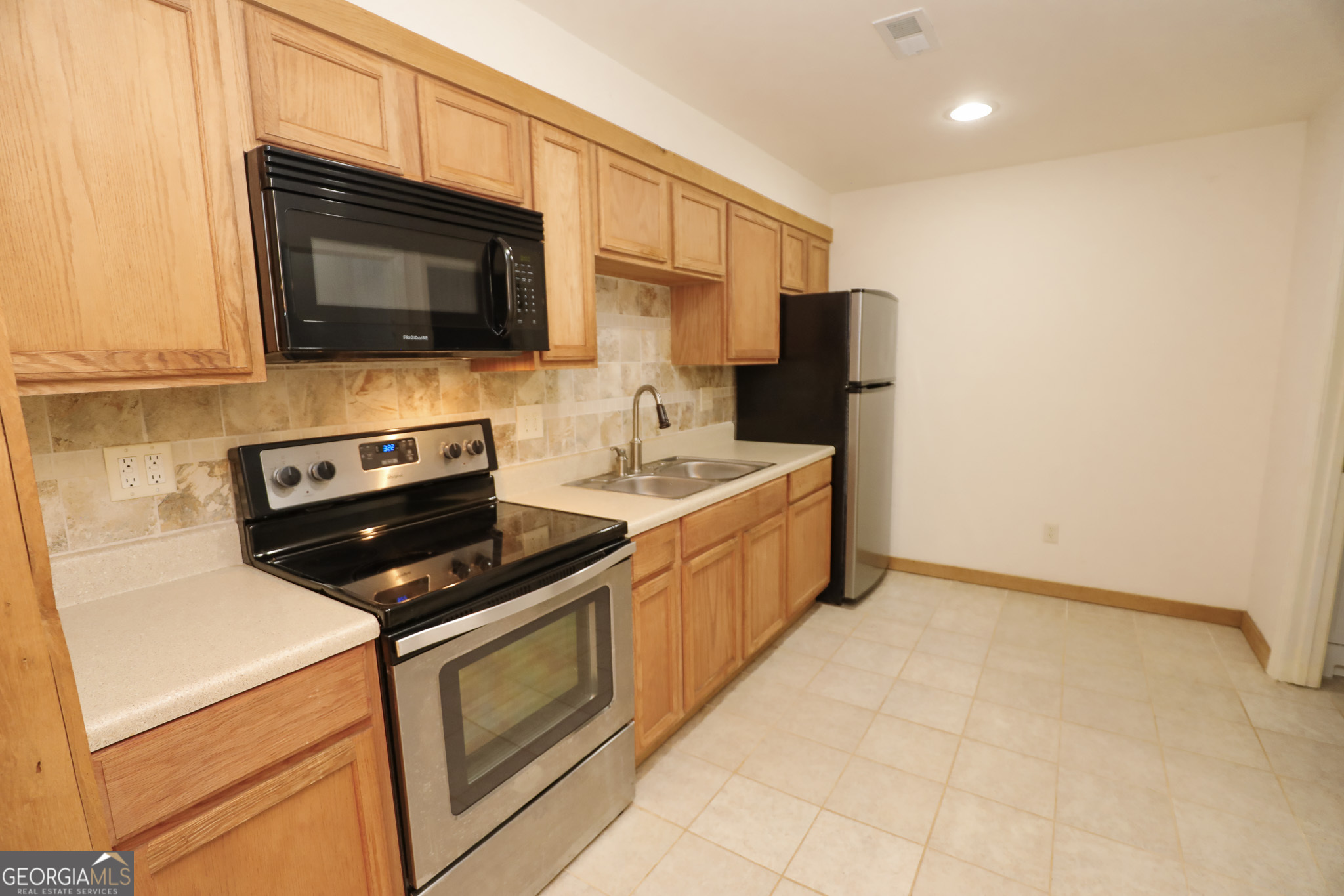 1017 Dr Bruce Jackson Road Newnan, GA 30263 - Photo 27 of 52 a kitchen with stainless steel appliances granite countertop a stove microwave and sink