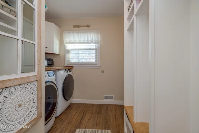 a view of walk in closet with window and hardwood floor