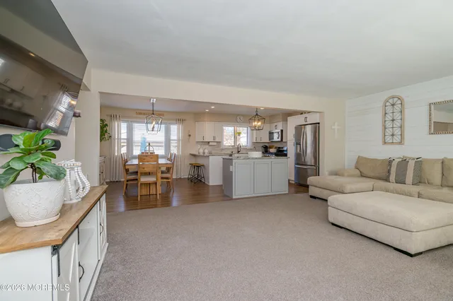 a living room with furniture and white kitchen