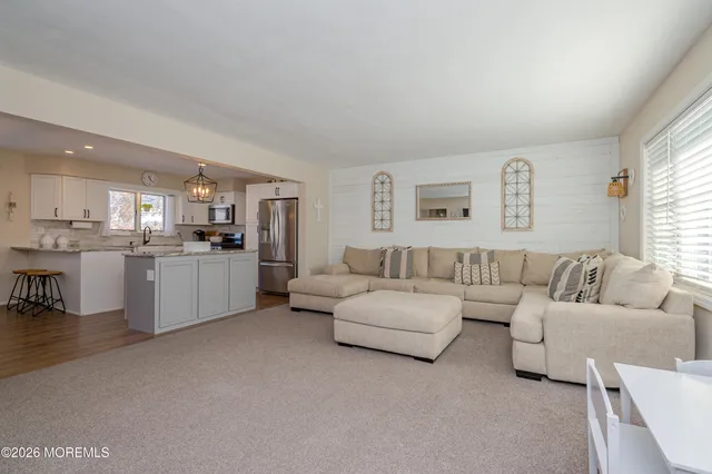 a living room with furniture and kitchen view