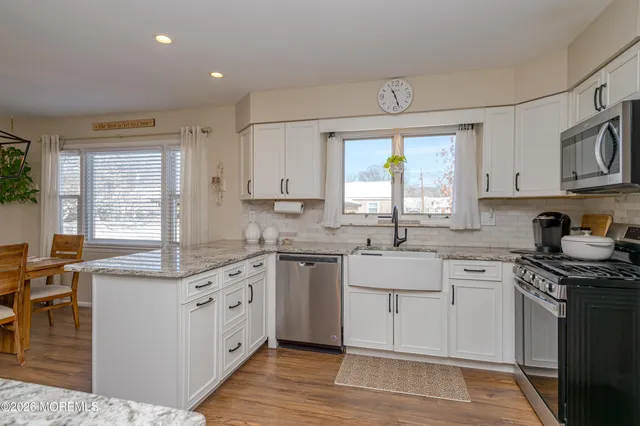 a kitchen with a sink cabinets appliances and a window