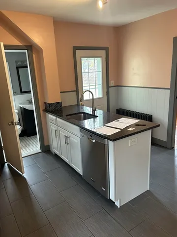 a kitchen with granite countertop a sink stove and cabinets