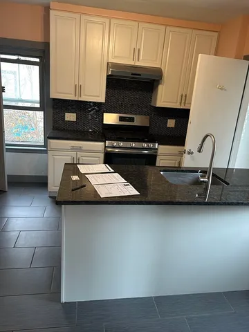 a kitchen with a sink a microwave and cabinets