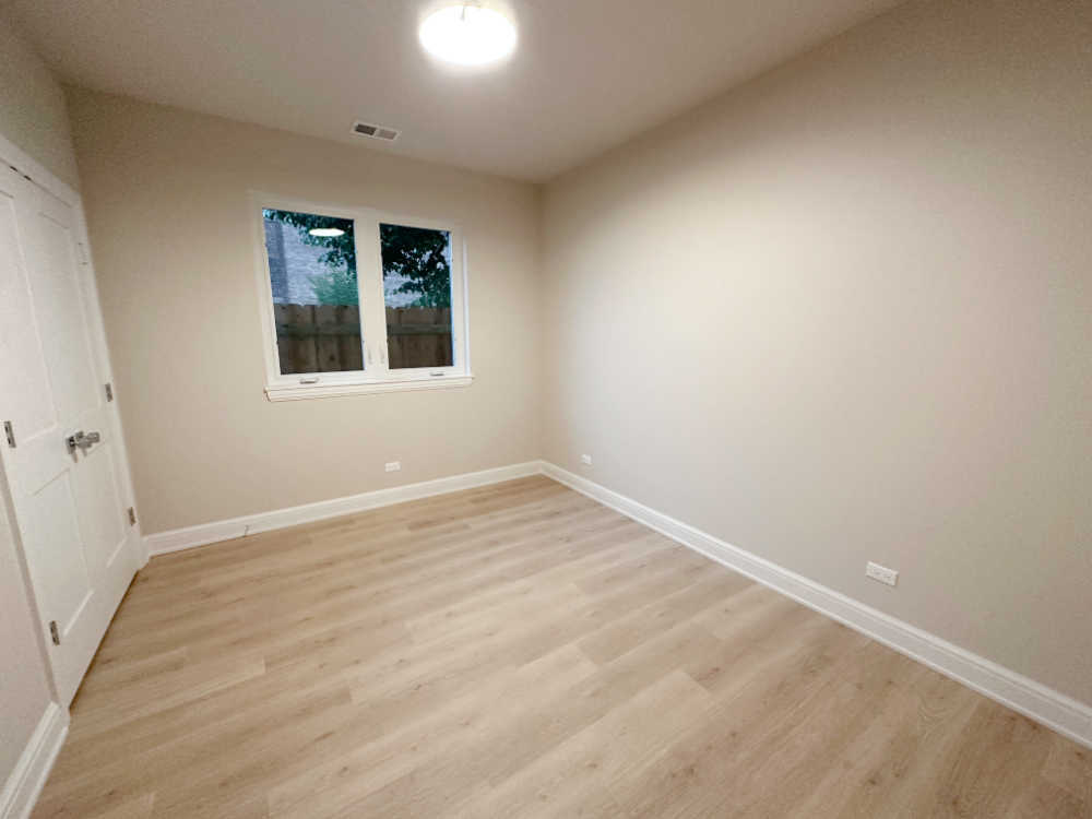 4315 South Indiana Avenue, Unit 2 Chicago, IL 60653 - Photo 12 of 16 an empty room with wooden floor and windows