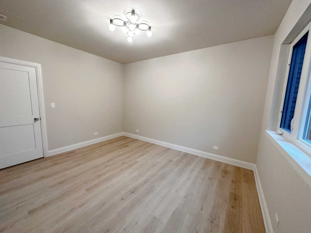 4315 South Indiana Avenue, Unit 2 Chicago, IL 60653 - Photo 8 of 16 wooden floor in an empty room with a window
