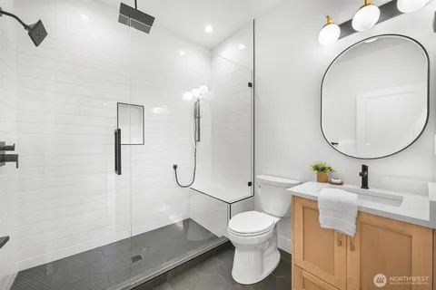 a bathroom with a sink a toilet and a mirror