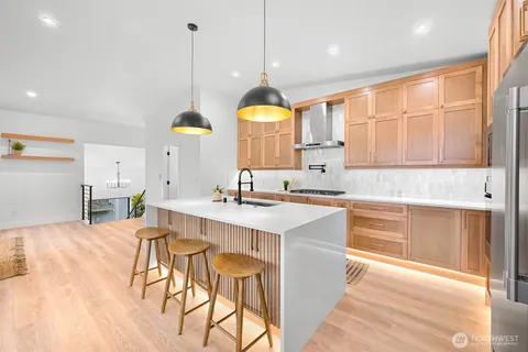 a kitchen with a dining table chairs sink and cabinets