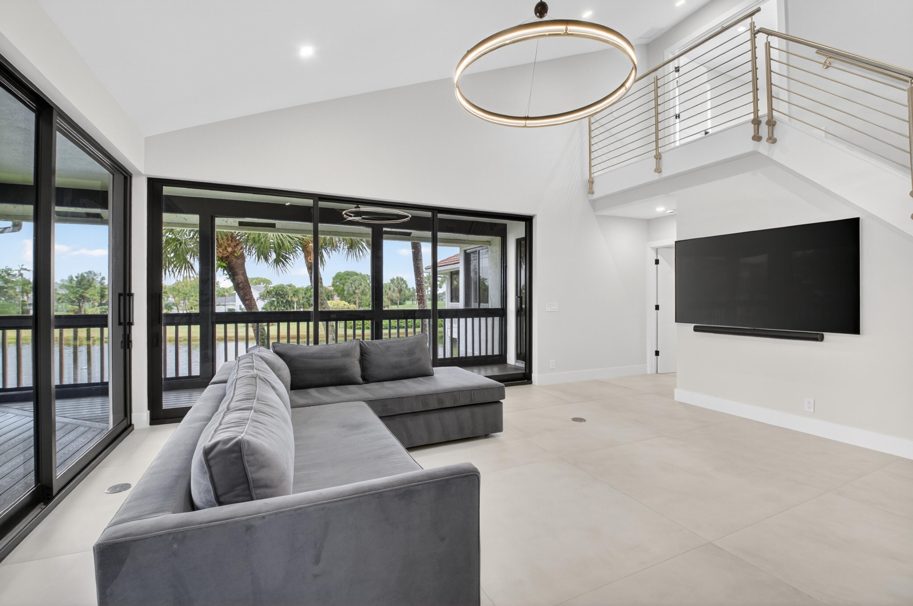 19221 Sabal Lake Drive, Unit 5124 Boca Raton, FL 33434 - Photo 18 of 98 a living room with furniture a flat screen tv and a floor to ceiling window