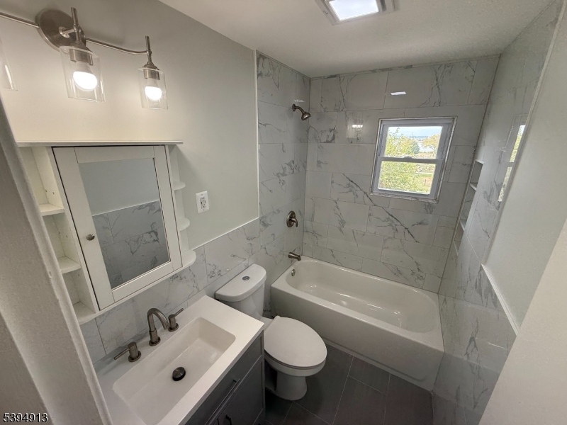 691 9th Street Secaucus, NJ 07094 - Photo 5 of 12 a bathroom with a sink toilet and shower